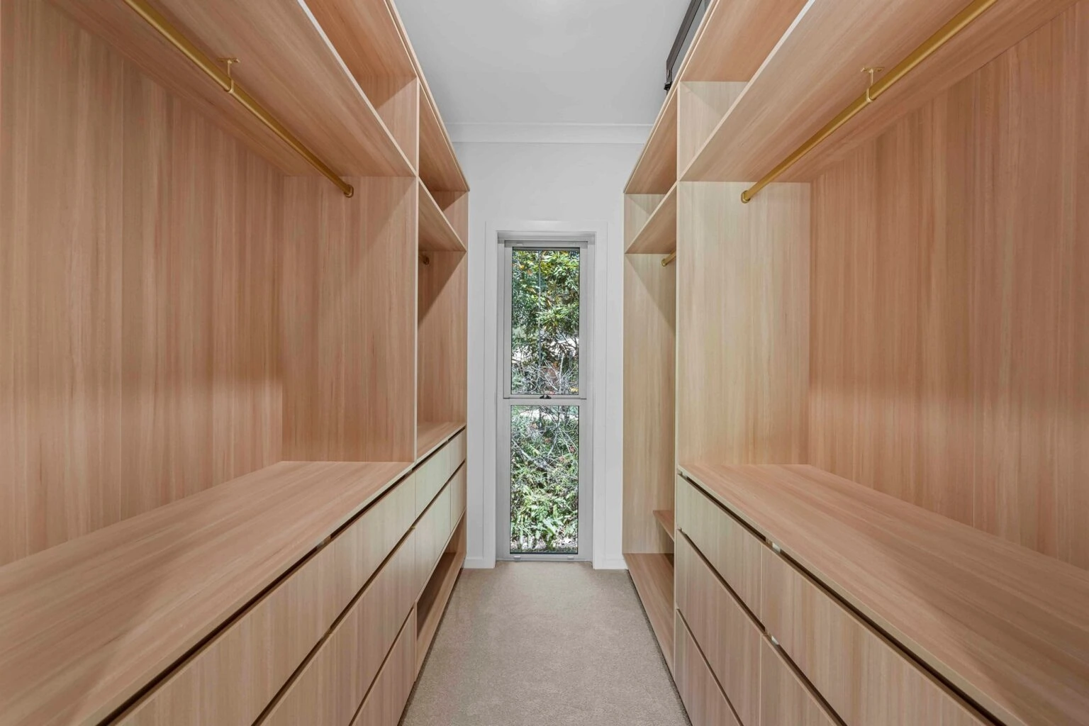 Walk-in wardrobe with timber shelving and gold rails at the Ney Road renovation, Capalaba