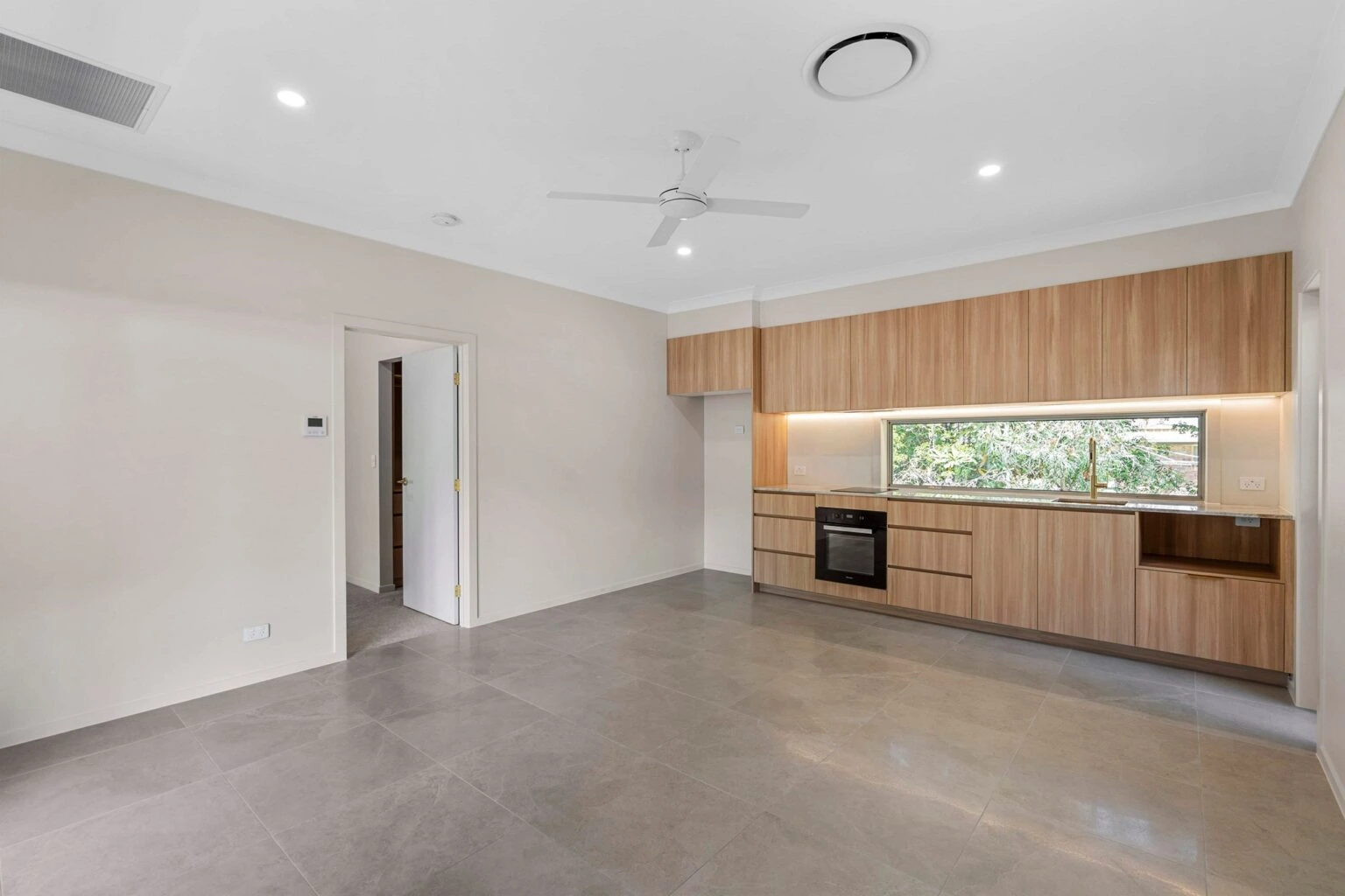 Open-plan kitchen and living area with timber cabinetry at the Ney Road renovation, Capalaba