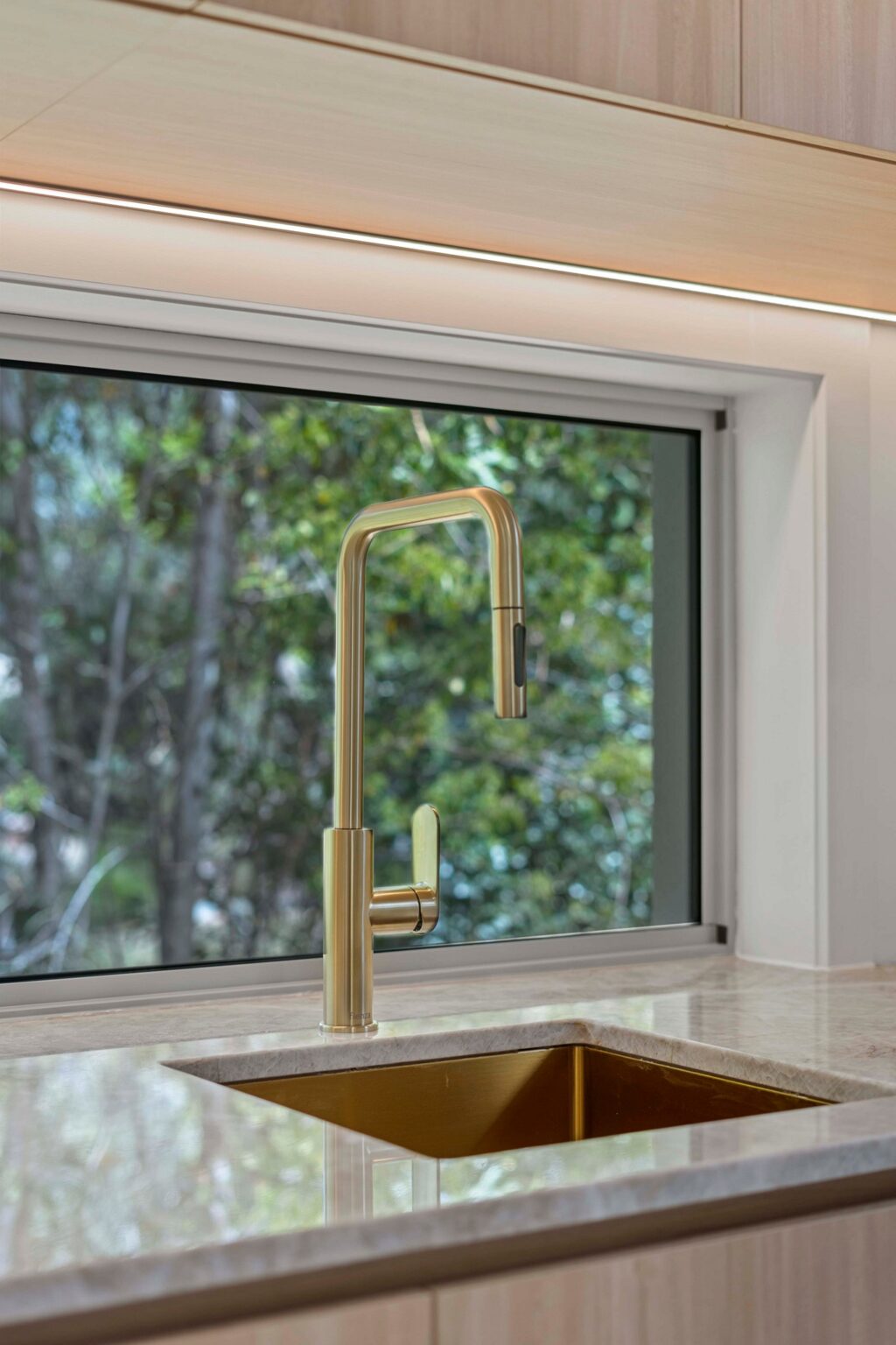 Kitchen sink with gold tapware and stone benchtop at the Ney Road renovation, Capalaba