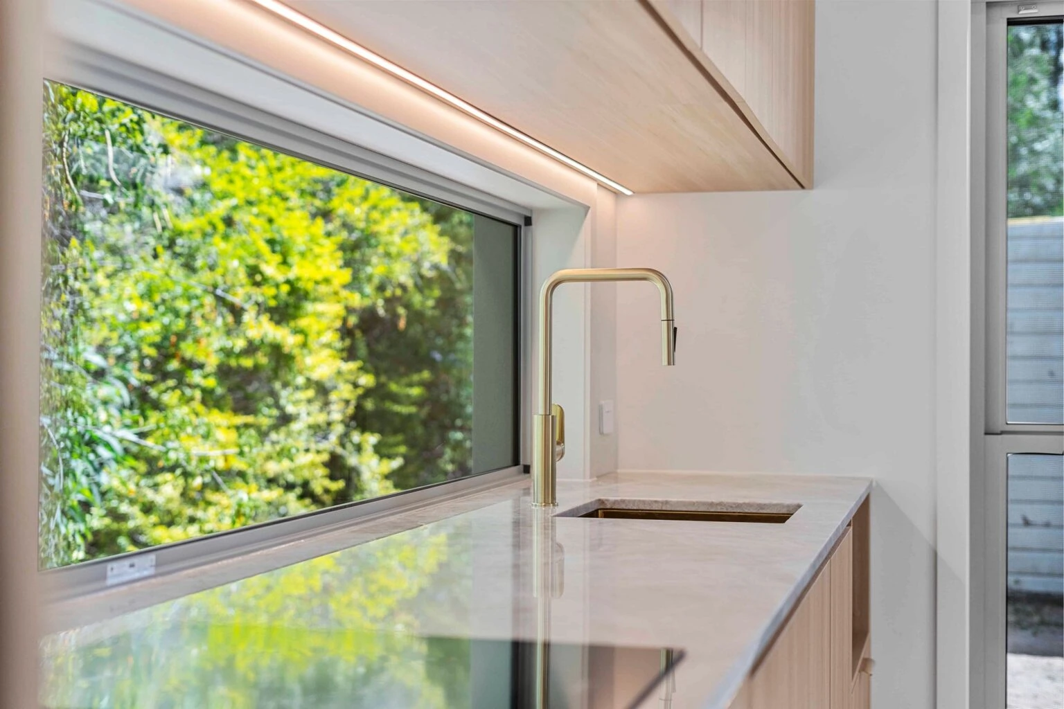 Kitchen sink beneath a window looking onto the garden at the Ney Road renovation, Capalaba