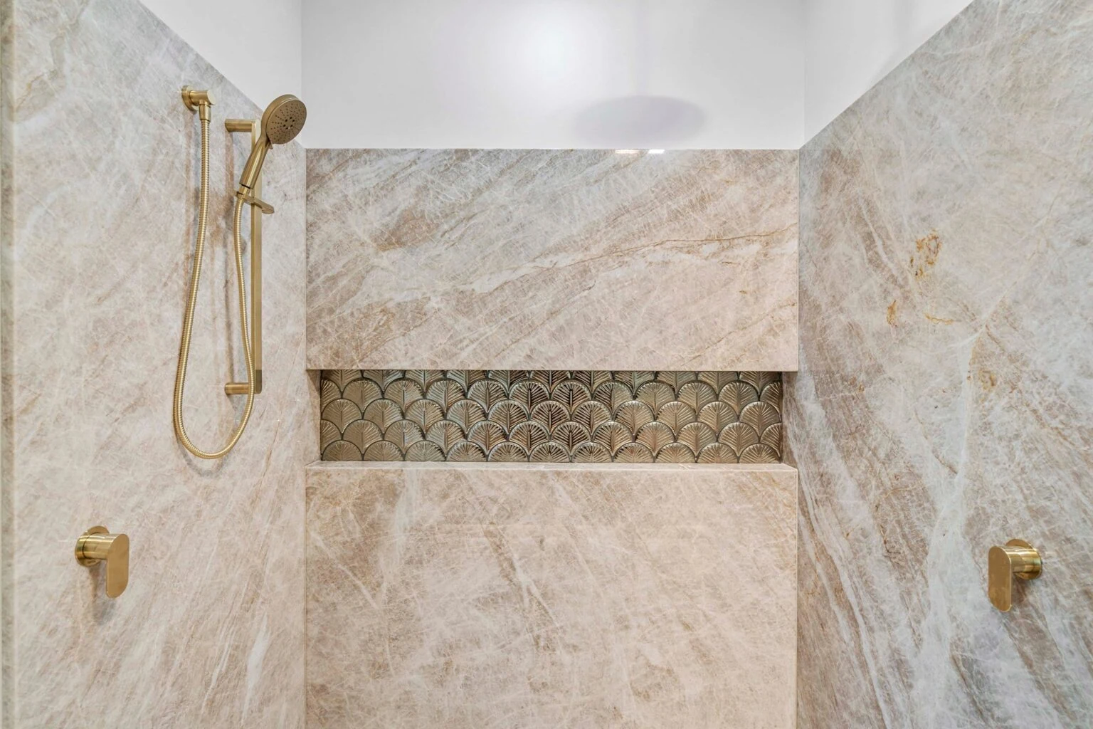 Shower niche with fan-pattern feature tile and gold fittings at the Ney Road renovation, Capalaba