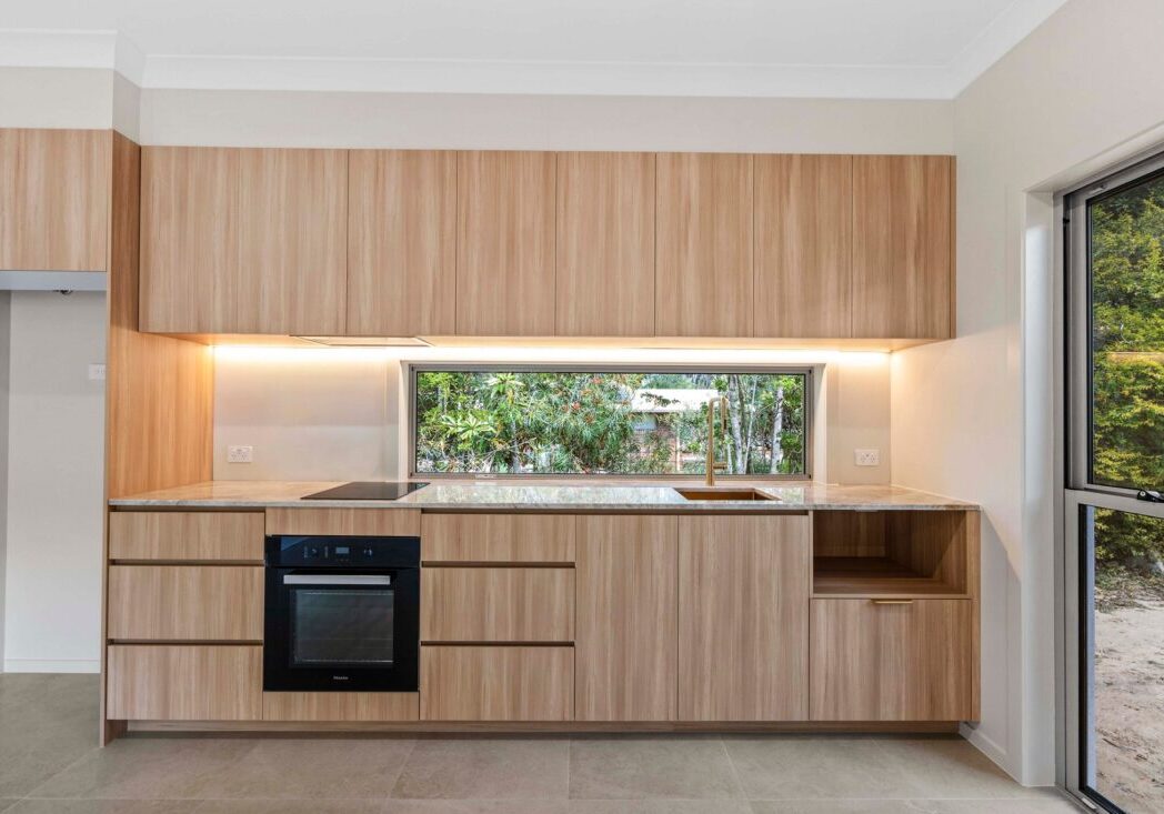 Kitchen with window splashback and gold tapware at the Ney Road renovation, Capalaba